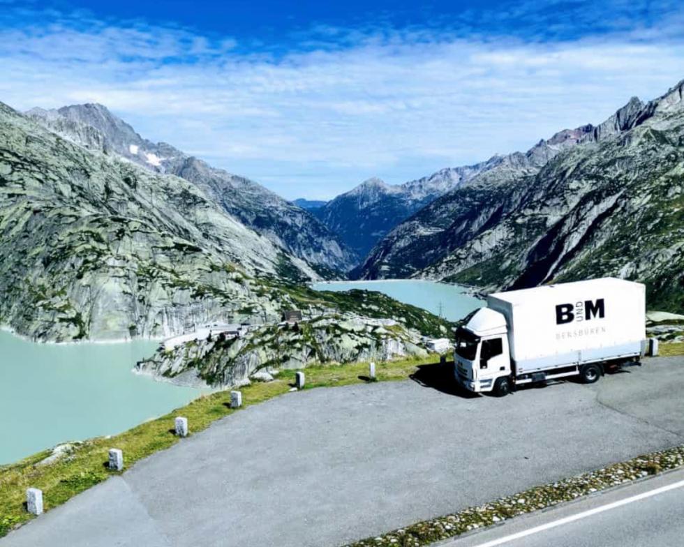 B+M Lieferlastwagen vor Alpenpanorama