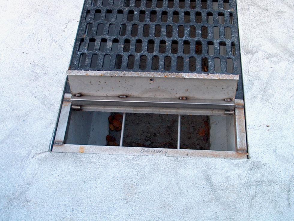 Ein geschlossener metallener Abwurfschachtmit rechts danebenliegendem Abwurfschacht, von Beton eingefasst, Draufsicht
